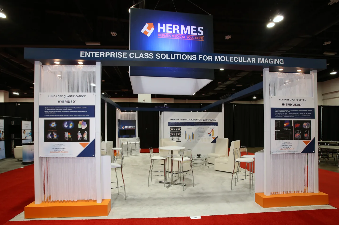 Hermes Medical Solutions exhibit with overhead sign and illuminated fibre columns