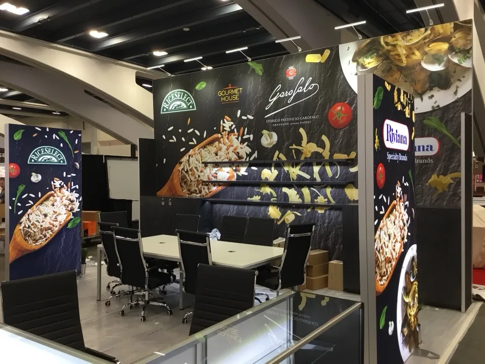 Dark exhibit environment with illuminated product graphics and meeting tables