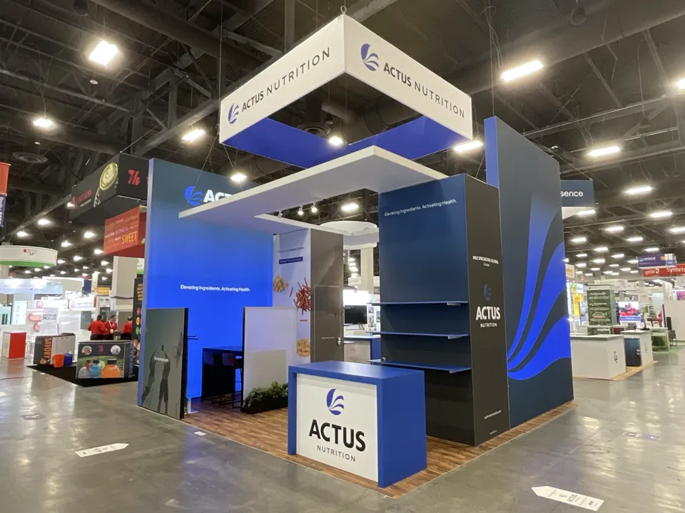 Actus Nutrition exhibit with overhead sign and blue graphic walls