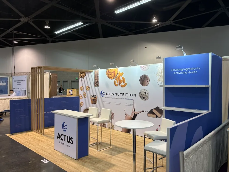 Actus Nutrition exhibit with timber frame and white bar tables