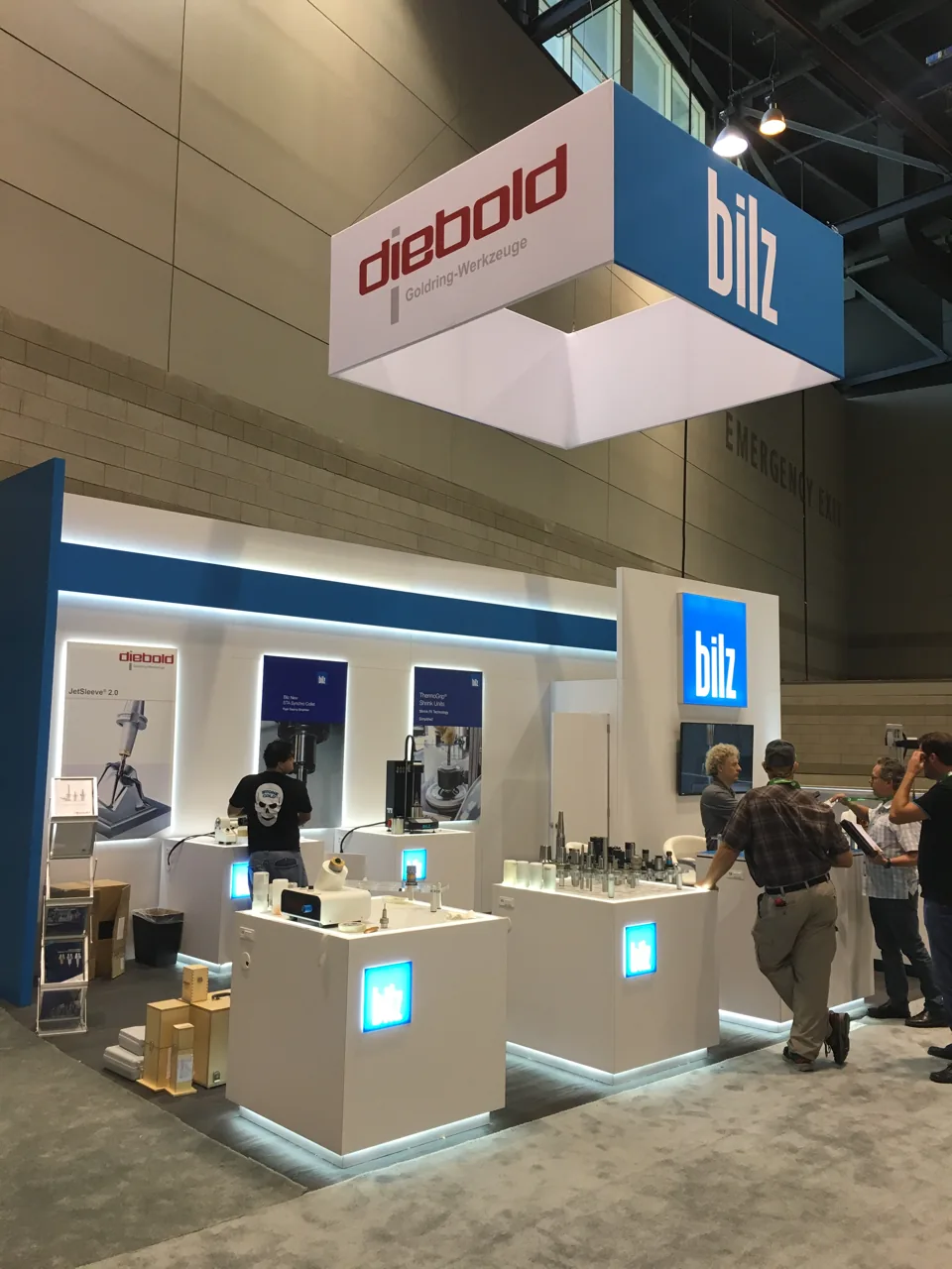 Bilz and Diebold exhibit with a hanging blue sign and illuminated counters
