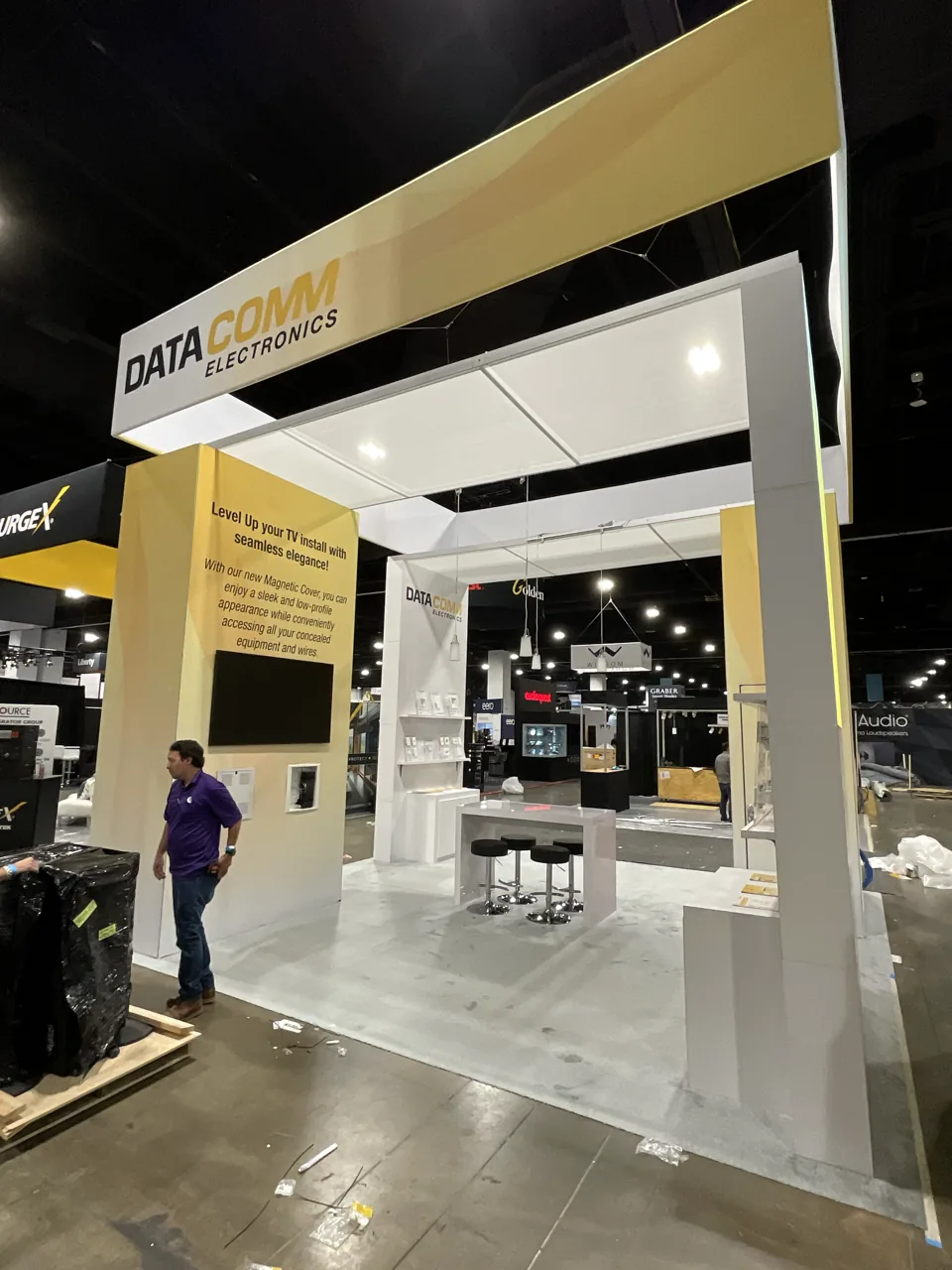 DataComm exhibit with a gold overhead frame and open floor plan