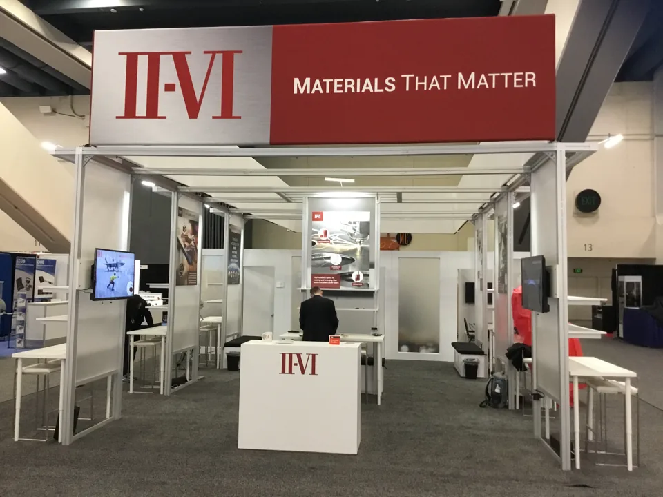 II-VI exhibit with a red overhead beam and open white framework