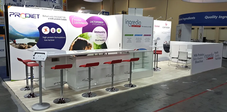 Prodiet exhibit with a long white bar counter and red stools under printed graphics