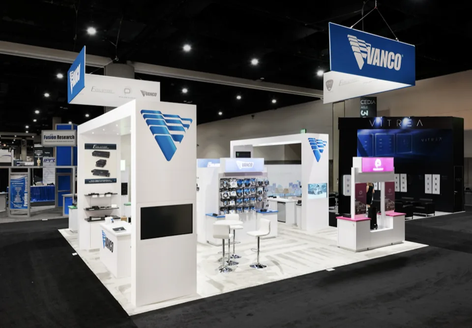 Vanco exhibit with glass product cases under a white canopy